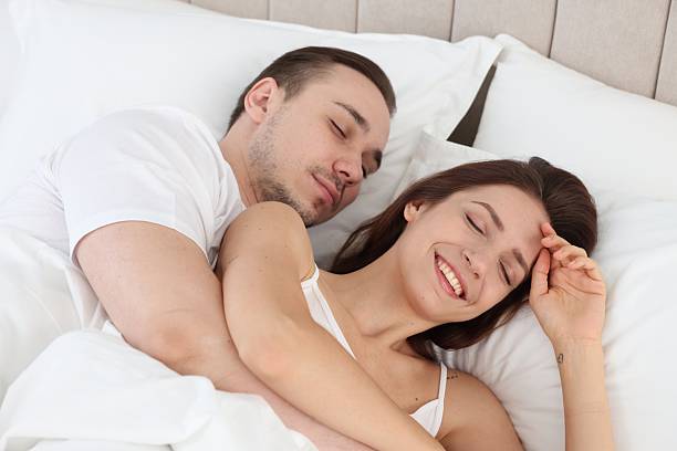 istock Cute couple lying in bed at home 2214183254