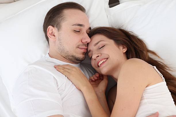 istock Cute couple lying on bed at home 2214183276