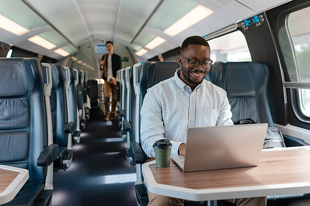istock Young African American man working on a laptop during a train journey 2214183911