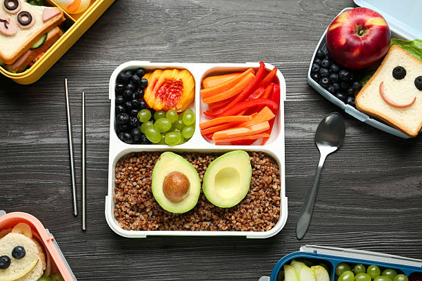 istock Lunch boxes with different snacks and cutlery on wooden table, flat lay 2214185816