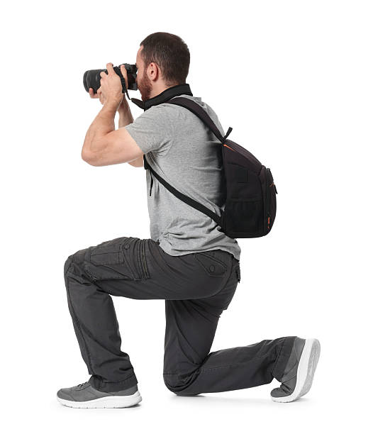 istock Photographer with backpack and camera taking picture on white background, back view 2214186286