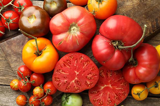 istock Different ripe tomatoes on wooden table, top view 2214190284