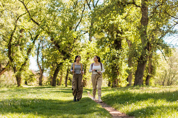 New York, NY, USA - June 22, 2020: Four teenaged friends walk happily together on the bridle path encircling the Jacqueline Kennedy Onassis Reservoir in Manhattan's Central Park. This day, June 22, is the first day of NYC's \