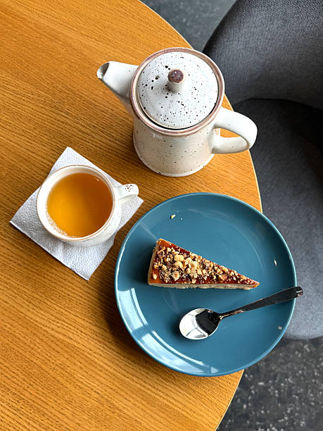istock Green Tea in Cup, Teapot, and Cheesecake with Walnuts on Table. Eating Out Concept. Handmade Mobile Photo, Top View, Not AI 2214190455