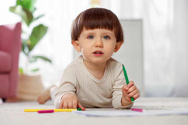 istock Cute little boy drawing on floor at home 2214191148