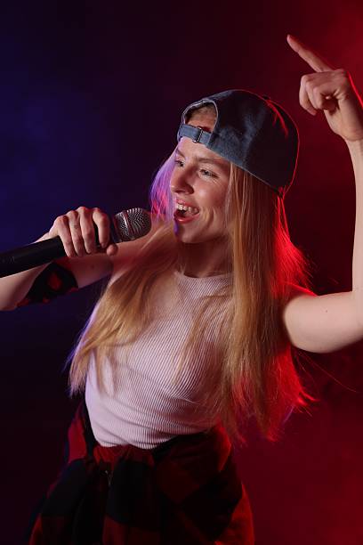 istock Talented singer performing on dark background with color lights 2214191558