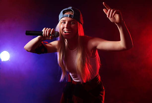 istock Talented singer performing on dark background with color lights and smoke 2214191613