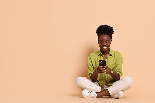 istock Happy woman with smartphone on beige background. Space for text 2214192478