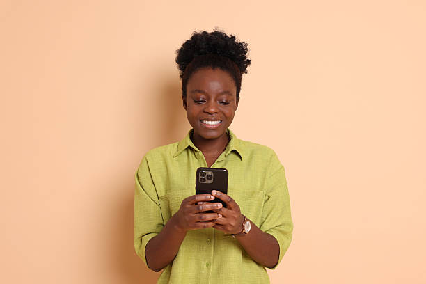 istock Happy woman with smartphone on beige background 2214192483