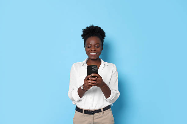 istock Happy woman with smartphone on light blue background. Space for text 2214192621