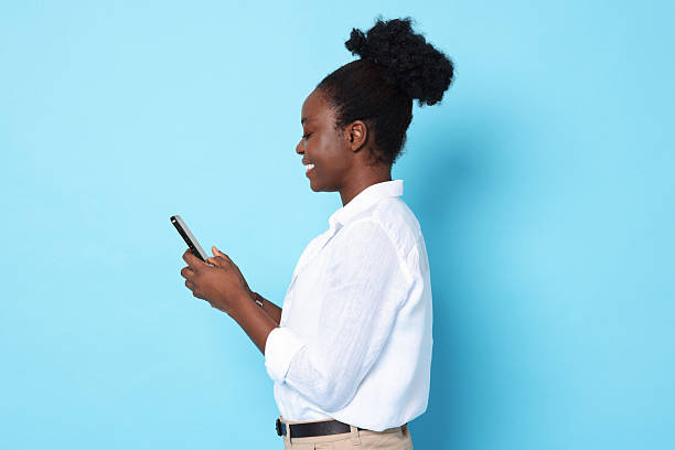 istock Happy woman with smartphone on light blue background 2214192658