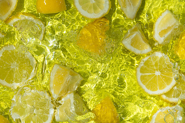 istock Vibrant yellow lemon pieces floating in motion water 2214196674