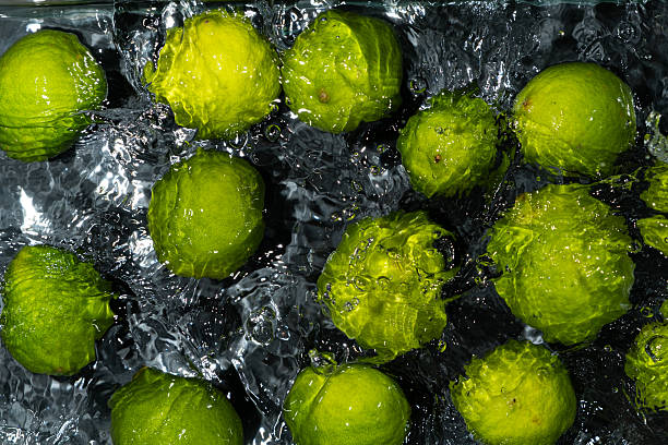 istock Whole Limes Drifting in Water with Soft Ripples 2214197974