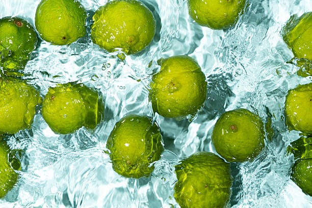 istock Green Limes Floating on Calm Water Background 2214197981
