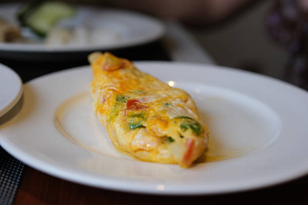 Stuffed omelette with tomatoes and spinach on light background with copy space. Top view, flat lay. High quality photo