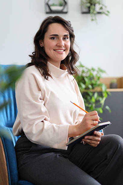 istock Young caucasian female writing in journal at home 2214200045