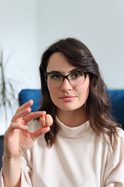 istock Young caucasian female holding small brain model in hand 2214200062