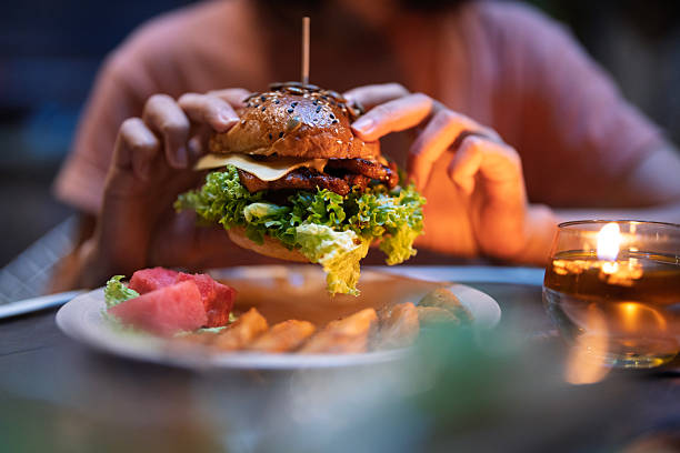 istock Woman Hand Holding Gourmet Burger with Side Dish 2214200256