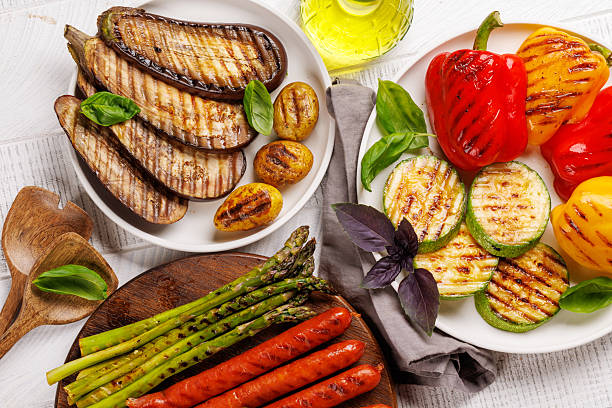 istock Assorted grilled vegetables including bell peppers, zucchini, eggplant, and sausages 2214200438