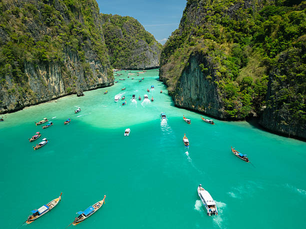 istock Longtail Boats in Turquoise Lagoon Surrounded by Cliffs at Phi Phi Islands 2214200566