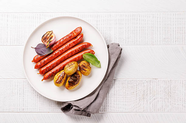 istock Grilled sausages served with roasted baby potatoes 2214200575