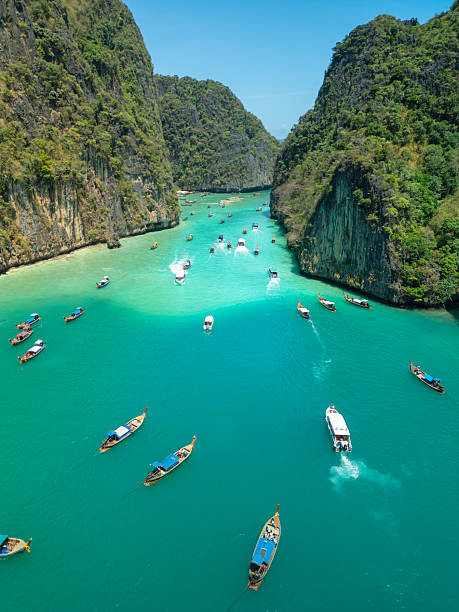 istock Aerial of Boats in Bright Turquoise Lagoon at Ko Phi Phi With Cliffs Around 2214200794