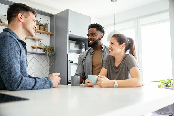 istock Multiethnic couple enjoying coffee at home with friends 2214201876