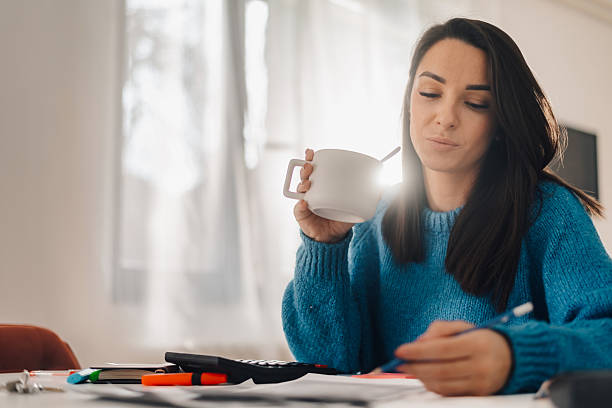 istock Focused woman drinking coffee and managing home finances 2214202609