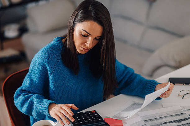 istock Focused freelancer calculating domestic bills at home office desk 2214202610