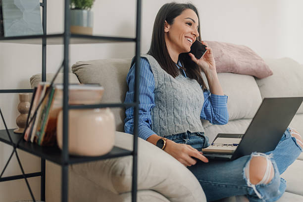 istock Smiling freelancer working from home and talking on phone 2214204468