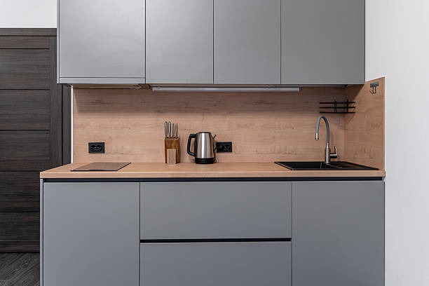 istock small modern kitchen in studio apartment. Stylish grey built-in kitchen with wooden countertop and backsplash. built-in furniture. electric cooktop. stainless steel appliances. kitchen unit 2214207213