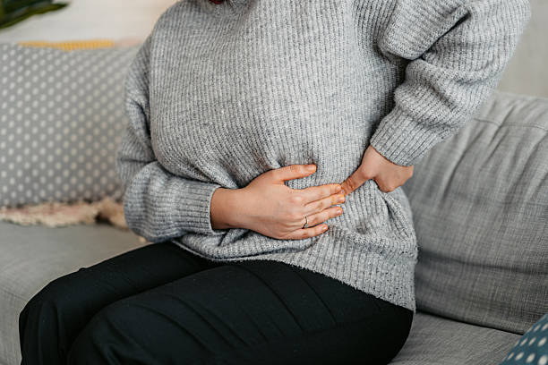 istock Young Woman Having A Stomachache At Home 2214207881