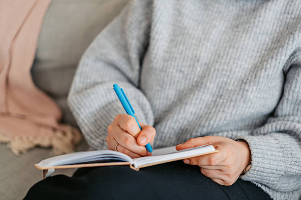 istock Young Woman Writing In A Diary At Home 2214208509