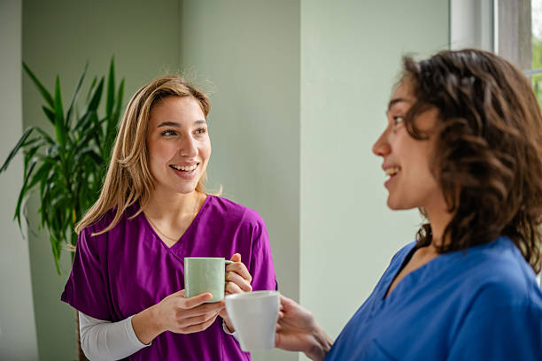 istock Young healthcare workers engage in a cheerful conversation while enjoying beverages in a bright medical facility 2214209373