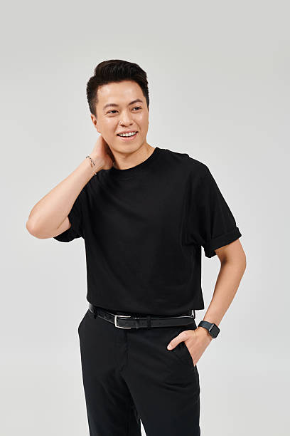 istock Stylish young man exudes confidence in modern, minimalistic black outfit while posing in studio 2214212279