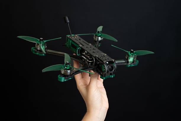 istock Professional modern drone with digital camera in hand on black background 2214212611