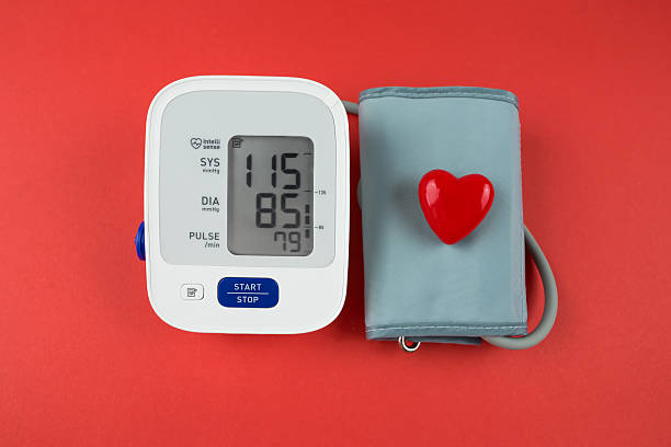 red heart and electronic tonometer on a red background.