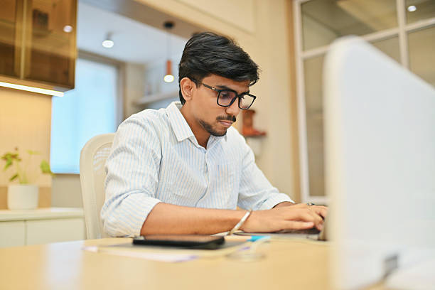 istock Focused young founder working on laptop in modern office 2214215814