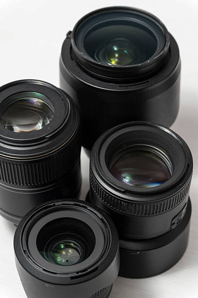 istock Group of four black camera lenses on white surface. 2214221007