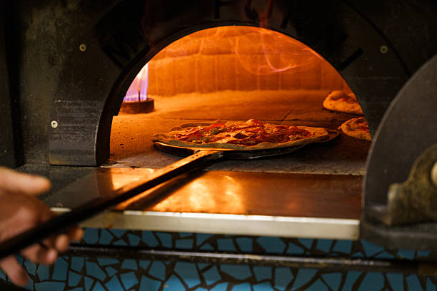 istock Placing pizza into an oven 2214224064