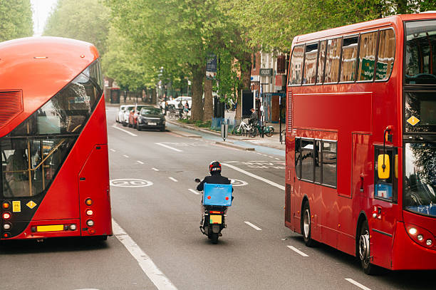 A scooter bike between two buses in London