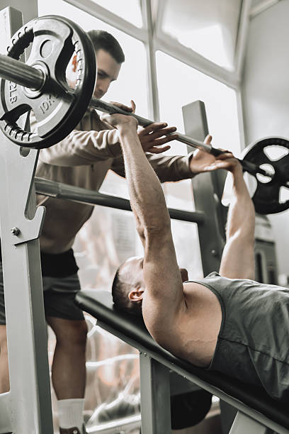 istock Male Friends Working Out Together One Spotting the Other While Doing Bench Press 2214227110