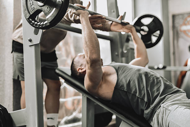 istock Male Fitness Trainer Spotting Client During Intense Bench Press Session 2214227143
