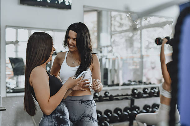 istock Friends Laugh Together While Browsing Workout Ideas Before Their Gym Session 2214228173