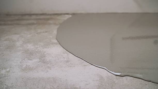 istock Filling floor with self-leveling concrete mix covering the rough surface 2214230451