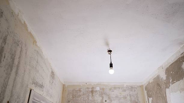 istock Light bulb hanging from ceiling in room under renovation 2214232043