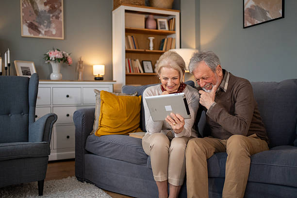 istock Senior couple watching funny videos on tablet and having fun 2214235945