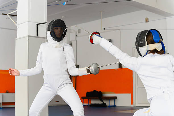istock Female fencer lunging forward to strike opponent indoors. 2214236983