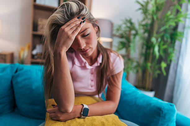 istock Young woman suffering from headache at home 2214239798