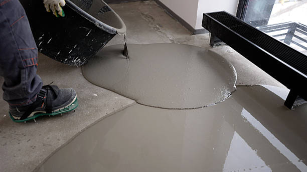 istock Construction worker pouring self-leveling concrete mix on the floor 2214241016